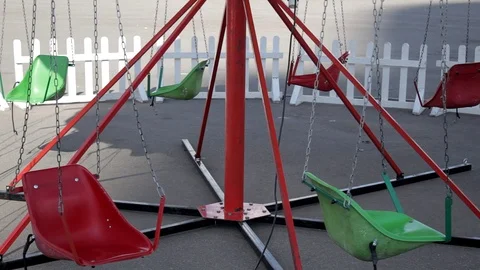 Empty children's carousel swinging on chains Stock Footage 117294849