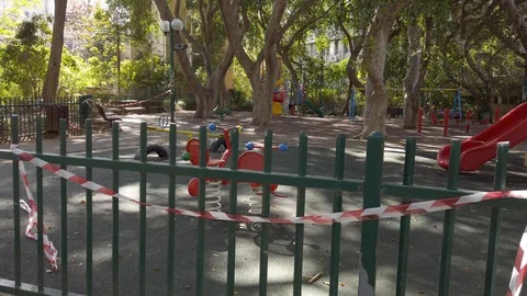 Empty children's playground closed with red and white tape - no entry or use Stock Footage 128088419