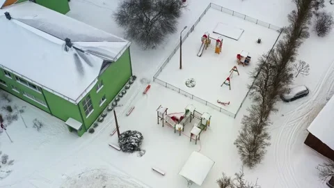 Empty children's playground covered in fresh snow in High angle top down drone Stock Footage 335893692