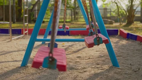 Empty children's playground at the park with swing swinging. Stock Footage 234255974
