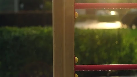 Empty children's playground in the rain. Rain drops falling on swing, wet Stock Footage 251738044