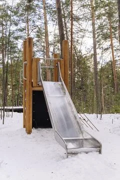 An empty children's slide in a winter amusement park among the pines Foto stock