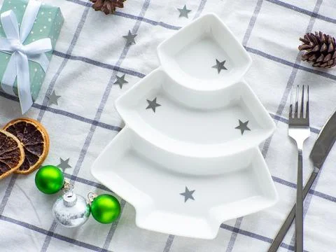 Empty christmas tree shaped white plate on towel background Stock Photos
