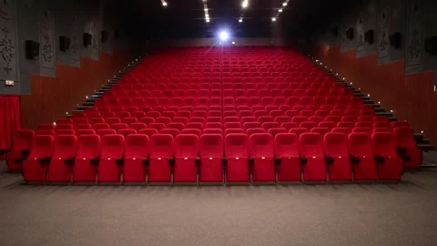 Empty cinema auditorium with rows of red velvet seats and ceiling lights Stock Footage 335780563