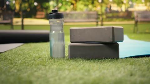 Empty city park with yoga brick and foam roller placed on mat on grass Stock Footage 346028069