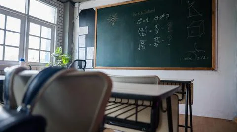 Empty classroom with chairs elementary school desks and chalkboard Stock Photos