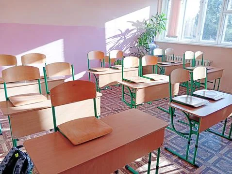 Empty classroom with desks and chairs at school. Stock Photos