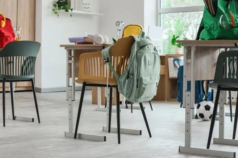 Empty classroom with student backpacks on chairs, modern school interior, edu Stock Photos