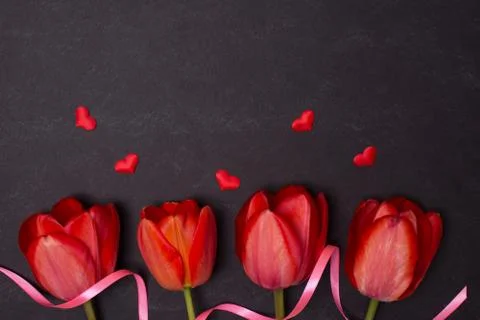 Empty clean black chalkboard with red tulips and hearts. Top view Stock Photos