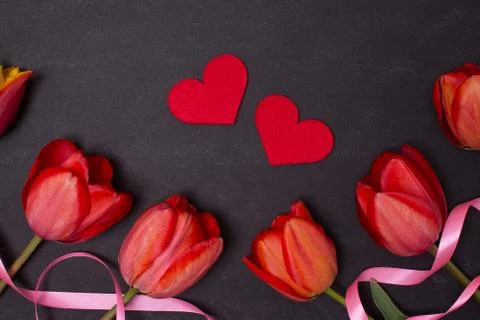 Empty clean black chalkboard with red tulips and hearts. Top view Stock Photos