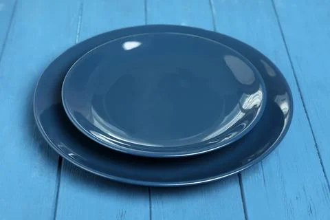 Empty clean ceramic dishware on blue wooden table, closeup Stock Photos