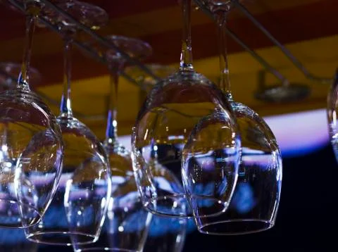 The empty clean glasses in bar, upside down, close up Stock Photos