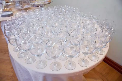Empty clean glasses standing in a row on a table prepared by the bartender fo Stock Photos