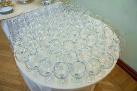 Empty clean glasses standing in a row on a table prepared by the bartender fo Stock Photos