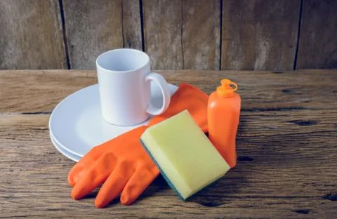 Empty clean plates and cup with dishwashing liquid, sponges, rubber Gloves Stock Photos