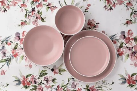 Empty clean plates on a white tablecloth with floral pattern, table top vie.. Stock Photos