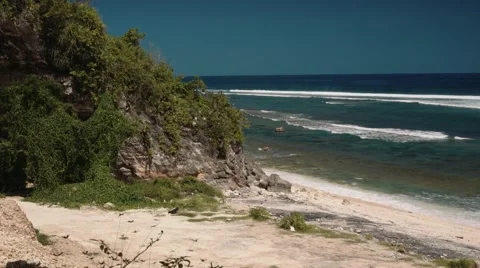 Empty clean white beach bordered by rocks with trees Video stock 63545419