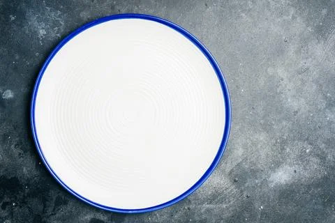 Empty clean white plate on gray stone background. Gray minimalism concept. Co Stock Photos