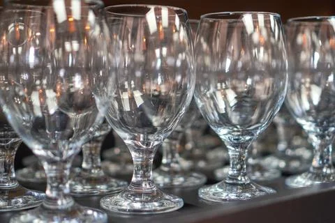 Empty Clean Wine Glasses Lined Up on Bar Counter Foto stock