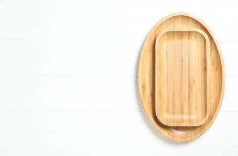 Empty clean wooden dishware on white table, top view. Space for text Stock Photos
