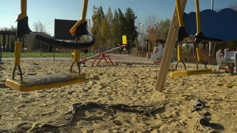 Empty closed children playground, moving kids swings, coronavirus Covid-19 virus Stock Footage 145190289