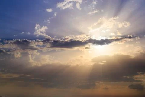 Empty cloudy sky from orange to blue with sun rays during the sunset Foto stock