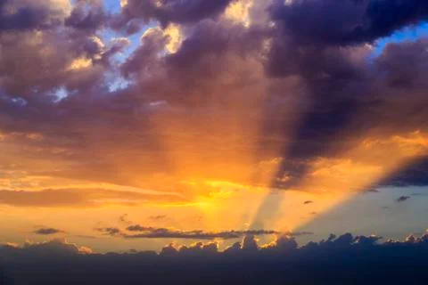 Empty cloudy sky from orange to blue with sun rays during the sunset Foto stock