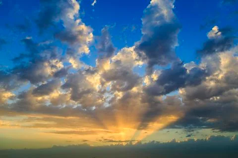 Empty cloudy sky from orange to blue with sun rays during the sunset Foto stock