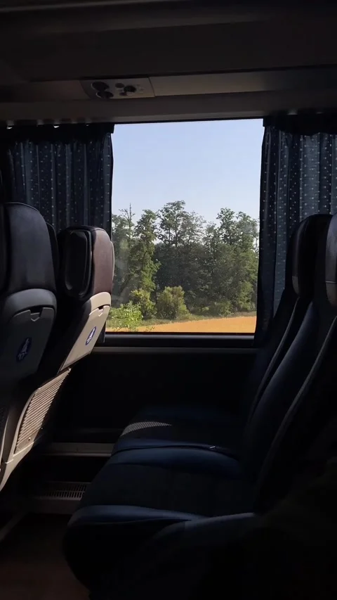 Empty coach interior with window view of passing green trees and golden field Stock Footage 341663044