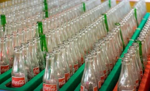 Empty Coca Cola bottles kept in factory storage, Stockfoto's