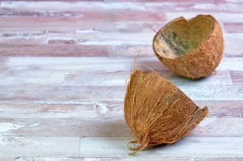 Empty coconut shell on a wooden table close-up with place for text Stock Photos