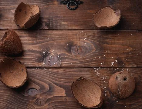 Empty coconut shells on a wooden table Stock Photos