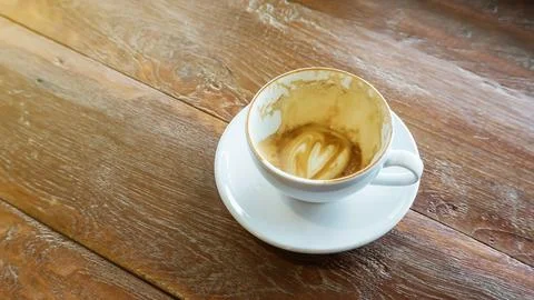 Empty coffee cup after drink on a wooden table. Stock Photos