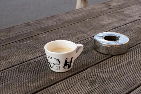 (empty) coffee cup and cigarettes ashtray, outside table Stock Photos