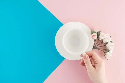Empty coffee cup and flower on beautiful pink and bright blue pastel backgrou Stock Photos