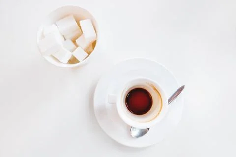 Empty coffee cup and glass with sugar on white background. End of coffee brea Stock-Fotos