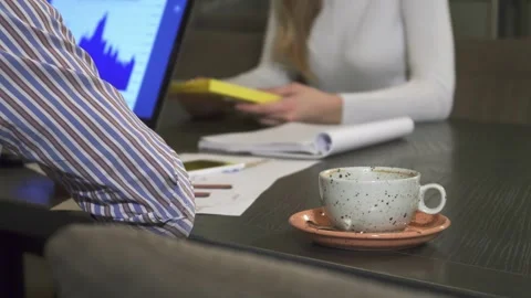 Empty coffee cup on a boardroom table as business professionals engage in a Stock Footage 311951753