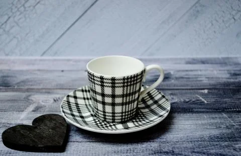 Empty coffee cup or tea cup on the plate and on the wooden table with black Stock Photos