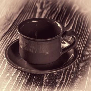 Empty coffee cup with saucer resting on a rustic wooden table surface Stock Photos