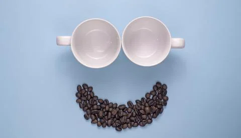 Empty Coffee Cups and Roasted Beans Smile Face on Blue Background Stock Photos