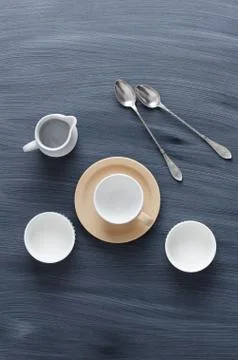 Empty coffee cups, milk jar and spoons Stock Photos