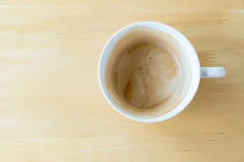 Empty coffee mug with coffee stain on wooden table Stock Photos