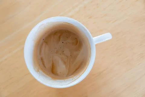 Empty coffee mug with leftover coffee on a wooden table Stock Photos