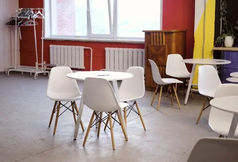 Empty coffee shop with white round tables in the office. Dining area in a cow Stock Photos