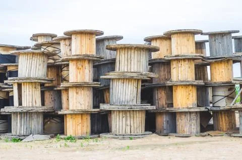 Empty coils from a high-voltage cable lie on a dump. Stock Photos