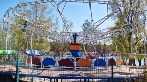Empty Colorful Carousel Swing Ride in Public Park Under Blue Sky Stock Footage 339003928