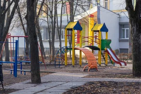 Empty colorful metal playground structure with slides and swings in a quiet.. Stock Photos