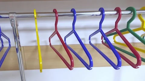 Empty colorful plastic clothes hangers on a metal rod. Stock Footage 321371859