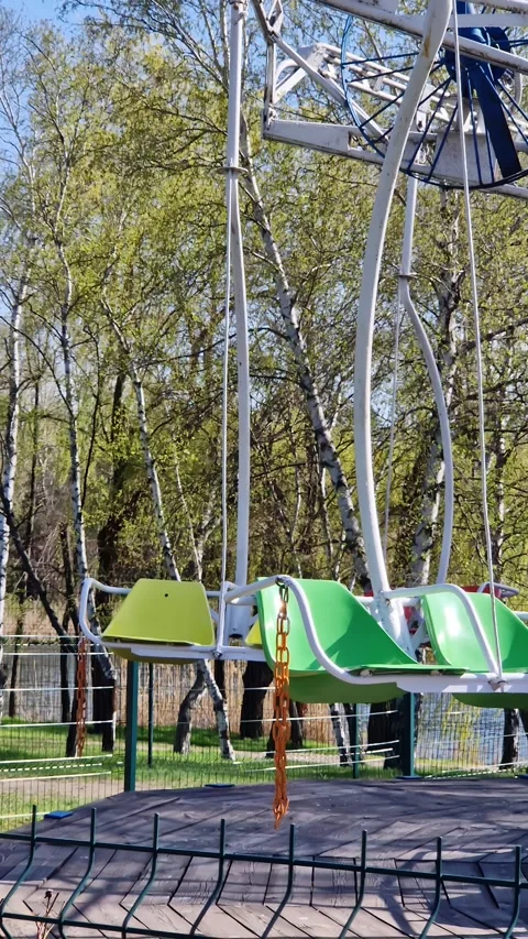 Empty Colorful Swing Carousel Ride Waiting in Spring Amusement Park Stock Footage 339002976