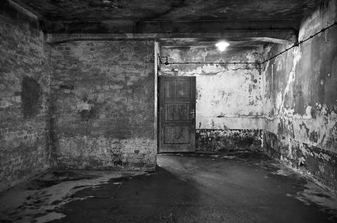 Empty concrete cell room with light bulb in Auschwitz camp Stock Photos